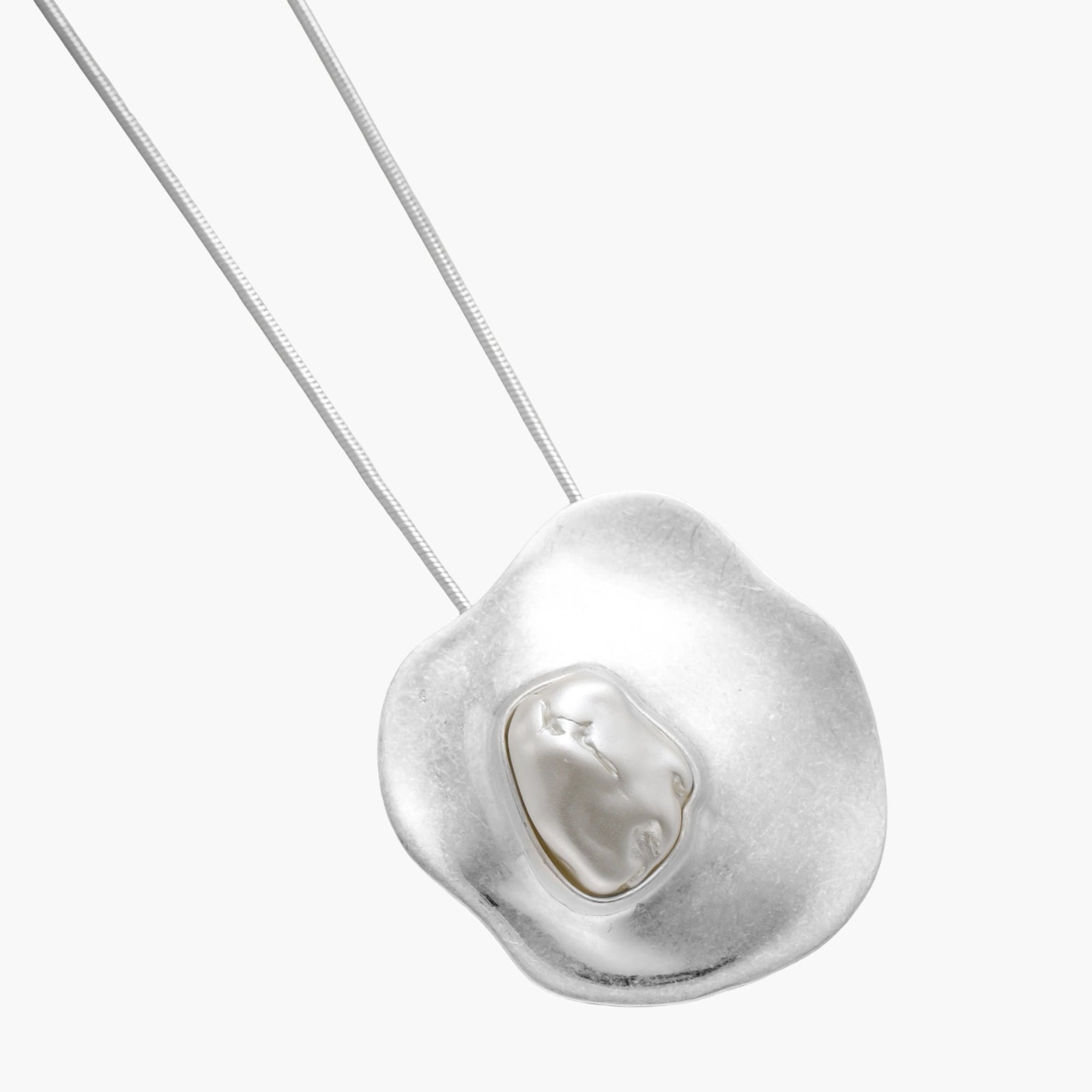 Organic-shaped gold pendant necklace with baroque pearl accent on adjustable chain, displayed against neutral background.